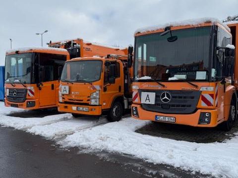 Drei Pressmüllfahrzeuge der RegioEntsorgung nebeneinander im Schnee